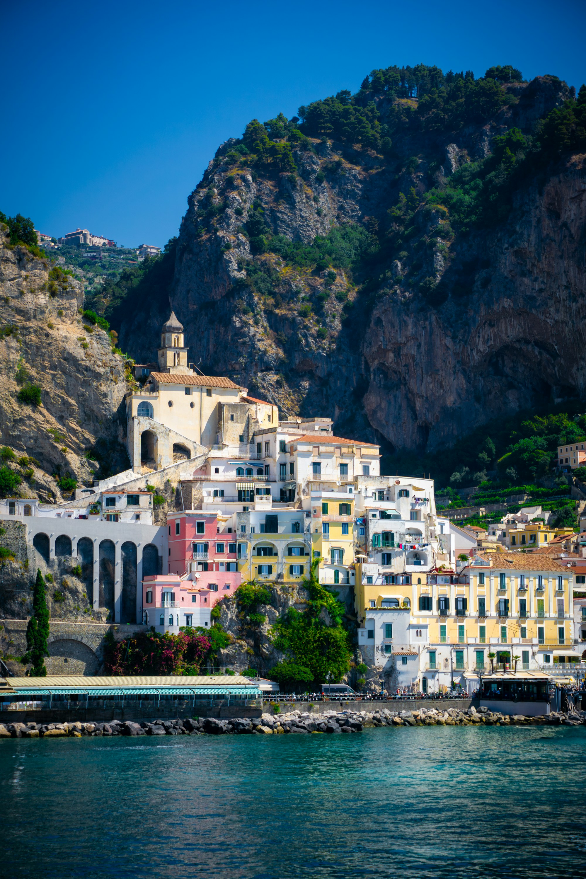 Colorful seaside buildings beneath dramatic cliffs on Italy’s Amalfi Coast